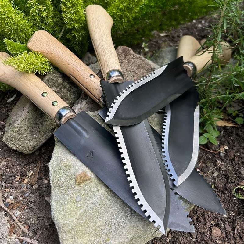 Hori Hori knives stacked in a garden setting