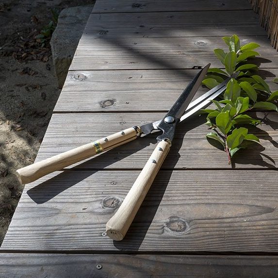 YH-128C Kihachi Curved Topiary Shears on a wooden deck of a traditional Japanese house